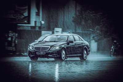 Voiture Mercedes roulant sous une forte pluie en ville