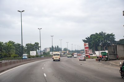 Abidjan – Scène urbaine sur la voie express avec stations-service et transport en commun