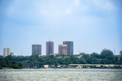 Skyline d'Abidjan vue depuis la lagune Ébrié – Tour moderne et végétation luxuriante
