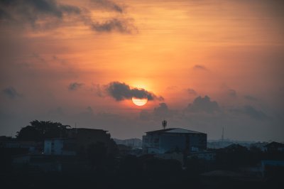 Soleil voilé sur Abidjan – Coucher de soleil dramatique en ville