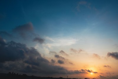 Ciel doré sur Abidjan – Soleil perçant sous les nuages