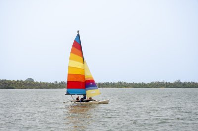 Small multi-colored sailboat sur le Abidjan lagune sous un clear ciel bleu