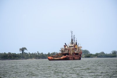 Old bateau flottant sur le lagune à Abidjan sous un clear ciel bleu