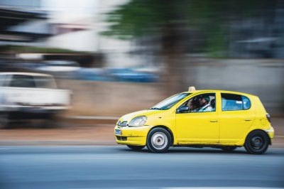 Yellow taxi (woro-woro) fonçant through le streets de Abidjan