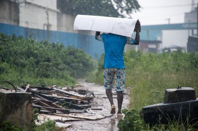 Homme à le pluie se protégeant himself avec un cardboard box