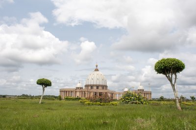 Vue panoramique de la Basilique Notre-Dame de la Paix entre deux arbres sculptés
