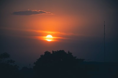 Coucher de soleil sur Abidjan avec silhouette de antenne et trees