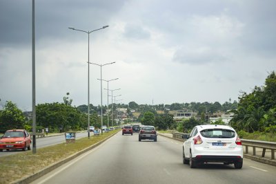 Scène de circulation à Abidjan – moderne road entre urban planning et vegetation