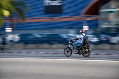 Moto driver roulant à front de Fnac à Abidjan – ivoirien urban scene