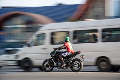 Jeune motocycliste filant à vive allure through le streets de Abidjan – Urban dynamism à Africa