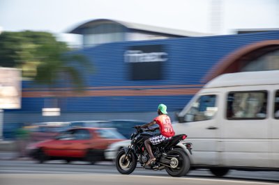 Africain motocycliste à motion à front de un shop à Abidjan – dynamique urban photo