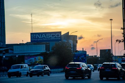 Coucher de soleil sur Abidjan – circulation urbaine et shop sign à silhouette