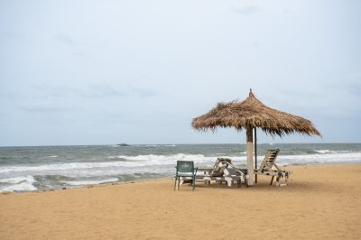 Paisible tropical plage avec straw parasol – sauvage africain côte