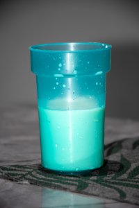 Turquoise plastic cup containing milk – Breakfast atmosphere