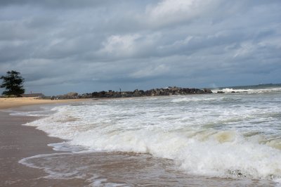 San Pedro plage avec déferlantes vagues et rocheux jetée sous un nuageux ciel – Côte d'Ivoire