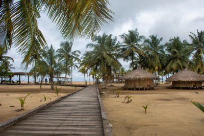 Wooden allée et traditionnel paillotes sur San Pedro plage, Côte d'Ivoire