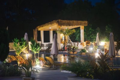 Illuminé piscine à nuit avec tropical pavilion et exotique plants