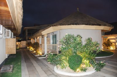 Illuminé allée à nuit avec moderne villas et tropical jardin