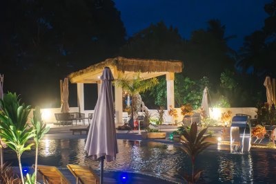 Illuminé piscine à nuit avec tropical pavilion et light reflections
