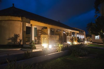 Éclairé tropical moderne villa à nuit avec landscaped jardin