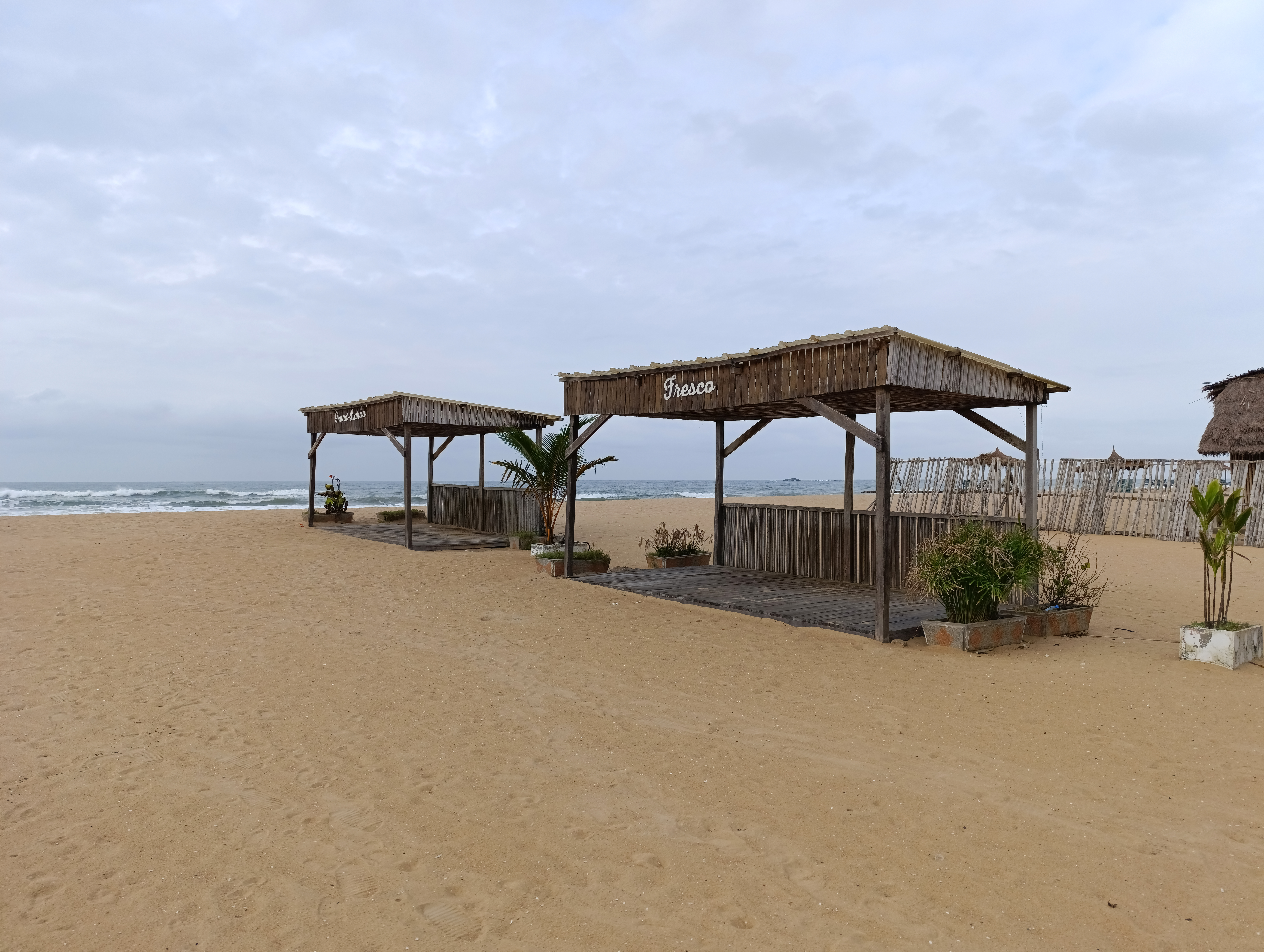Fresco plage à Côte d'Ivoire – traditionnel straw paillotes par le Atlantic océan