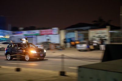Festive urban scène nocturne à Côte d'Ivoire – en mouvement voiture avec celebration