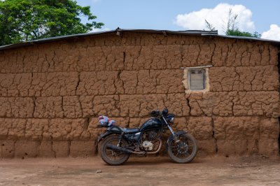 Moto garés à front de un en terre cuite house – africain rural life