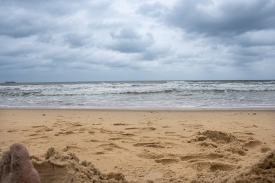 Doré sable plage et Atlantic vagues sous un nuageux ciel