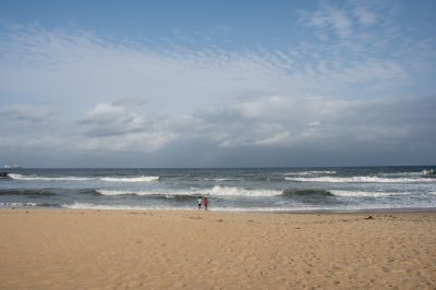 Two people face à le Atlantic océan vagues sur San Pedro plage, Côte d'Ivoire