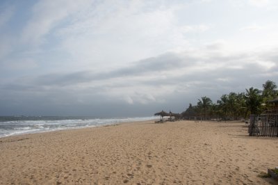 San Pedro plage avec cocotiers et paillotes sous un nuageux ciel – Côte d'Ivoire