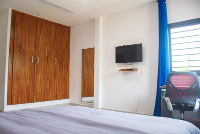 Moderne chambre avec wooden closets, éclairé double, et wall-mounted télévision