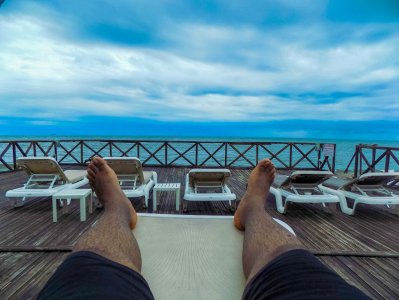 Immersive view de un moment de détente à Kribi, un seaside complexe hôtelier à Cameroun. Legs stretched out face à le Atlantic océan