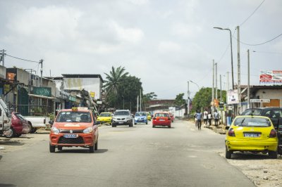 Scène de rue à Abidjan, le economic capital de Côte d'Ivoire. It shows coloré taxis, cars et pedestrians à un typical africain vie quotidienne atmosphere.