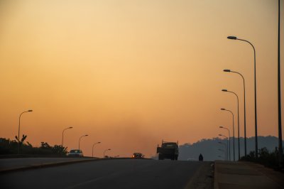 Un doré coucher de soleil sur un road à Yaoundé, Cameroun. Bathed à warm, soothing light, vehicles et streetlights stand out à silhouette.