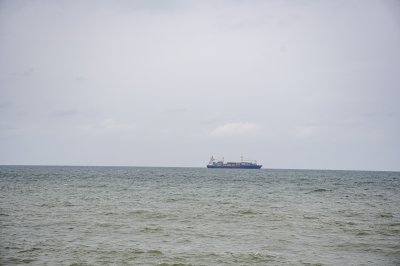 Un cargo navire naviguant off le côte de Abidjan, Côte d'Ivoire. le minimalist et paisible scene highlights le Atlantic océan et le vastness de le horizon.