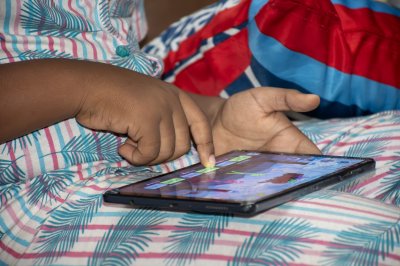 Enfant Using un tablette While Lying sur un Bed à Home