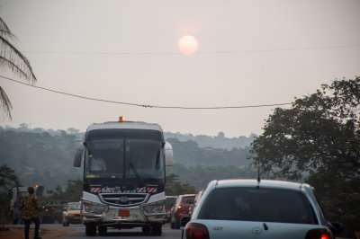 Le sun sets behind un en mouvement bus sur un camerounais road.