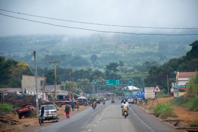 Typical urban scene de Cameroun showing le entrée vers un small, bustling town, lined avec shops et vehicles.