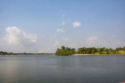 Un body de water entouré de tropical vegetation, sous un partly clear ciel