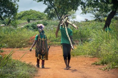 Un couple revenant depuis le fields à rural Africa, marchant sur un red dirt piste