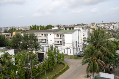 Bâtiments et un rue bordée de cocotiers à Abidjan