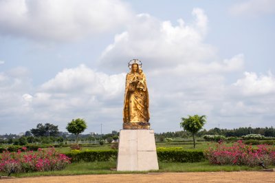 Statue peinte en or de le Vierge Marie avec le enfant Jésus à ses bras à le jardins de le Basilique de Notre-Dame de la Paix