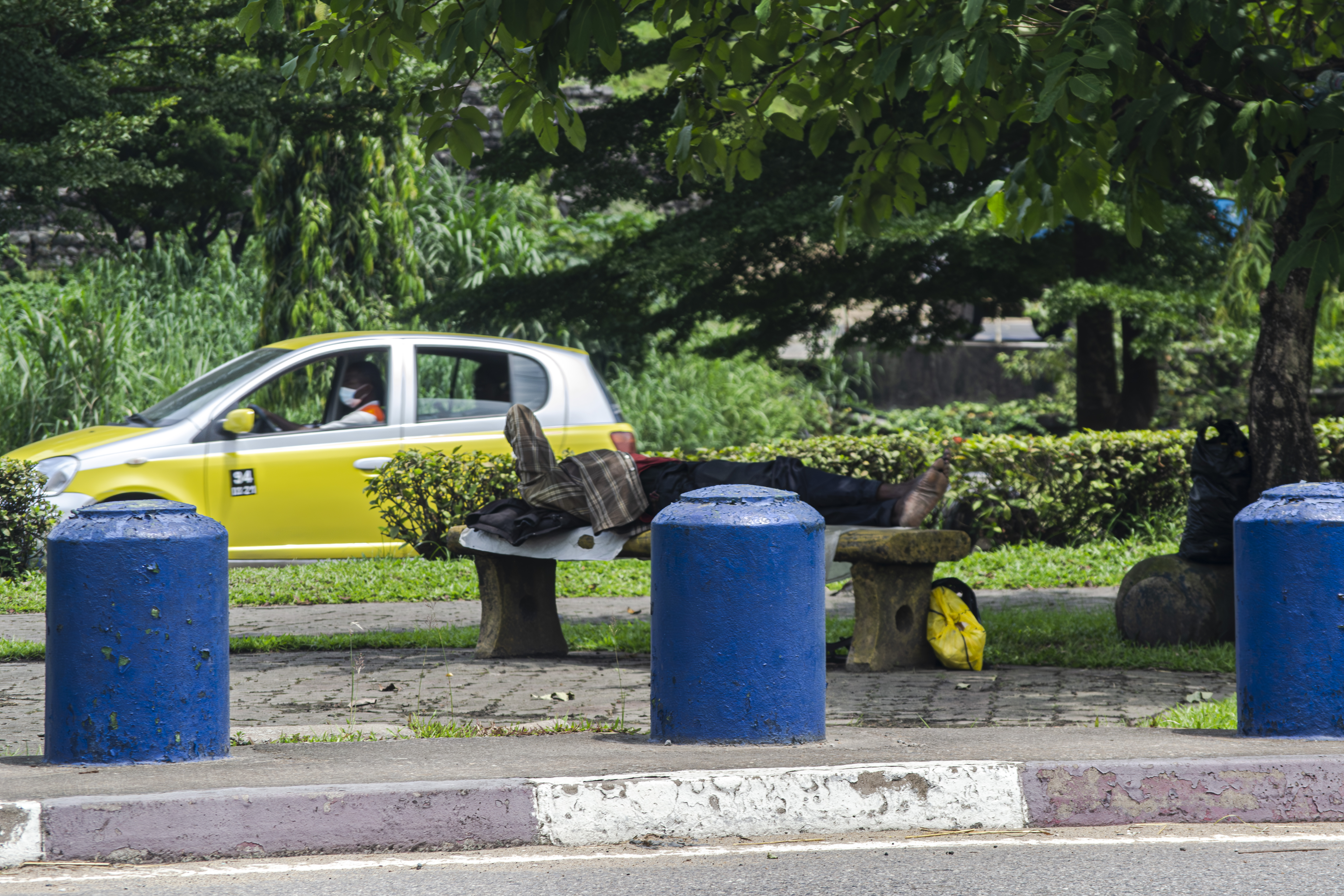Sans-abri allongé sur un banc de parc à Douala, Cameroun.