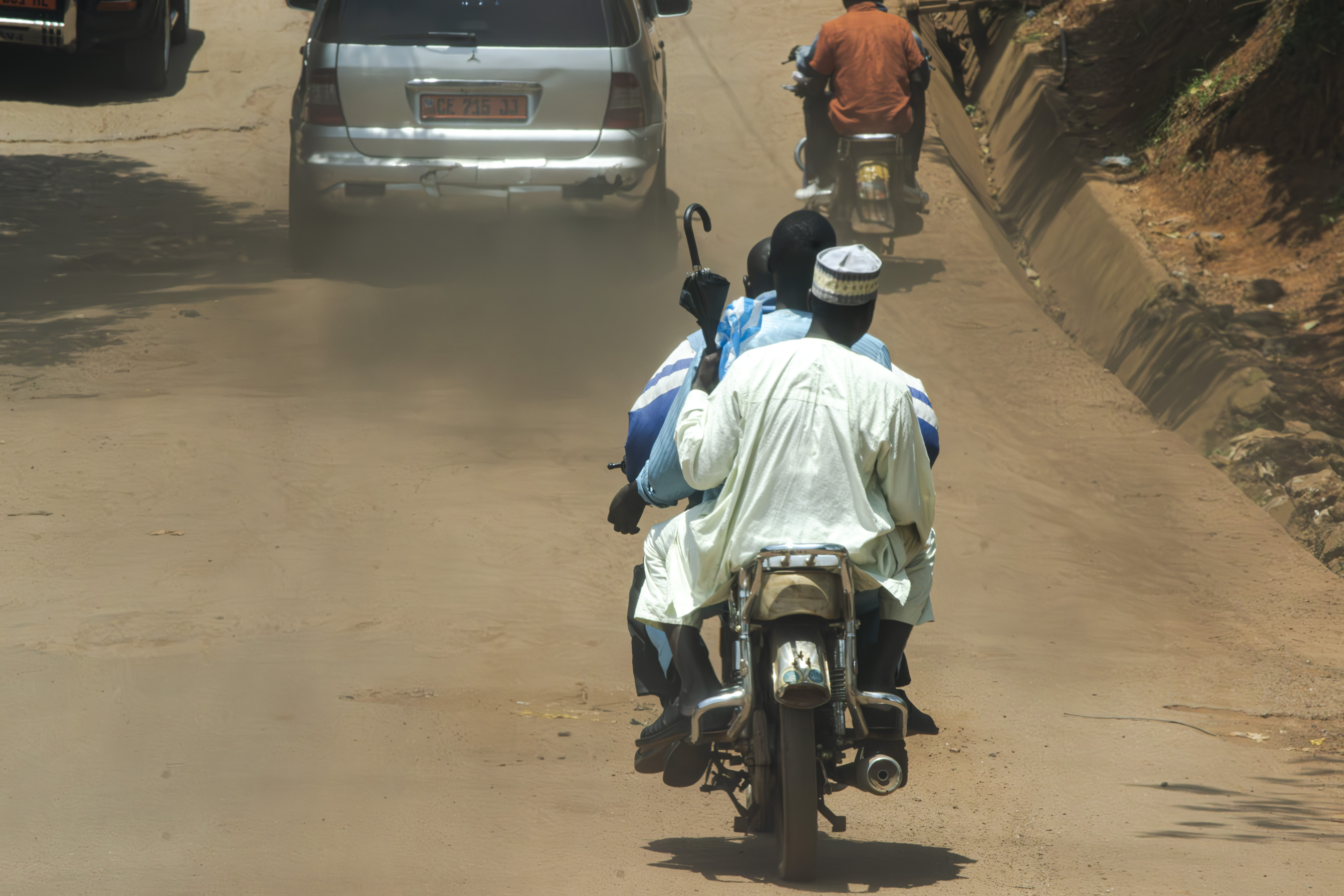Moto-taxi Circulation sur un route non bitumée à le Omnisport quartier de Yaounde, Cameroun.