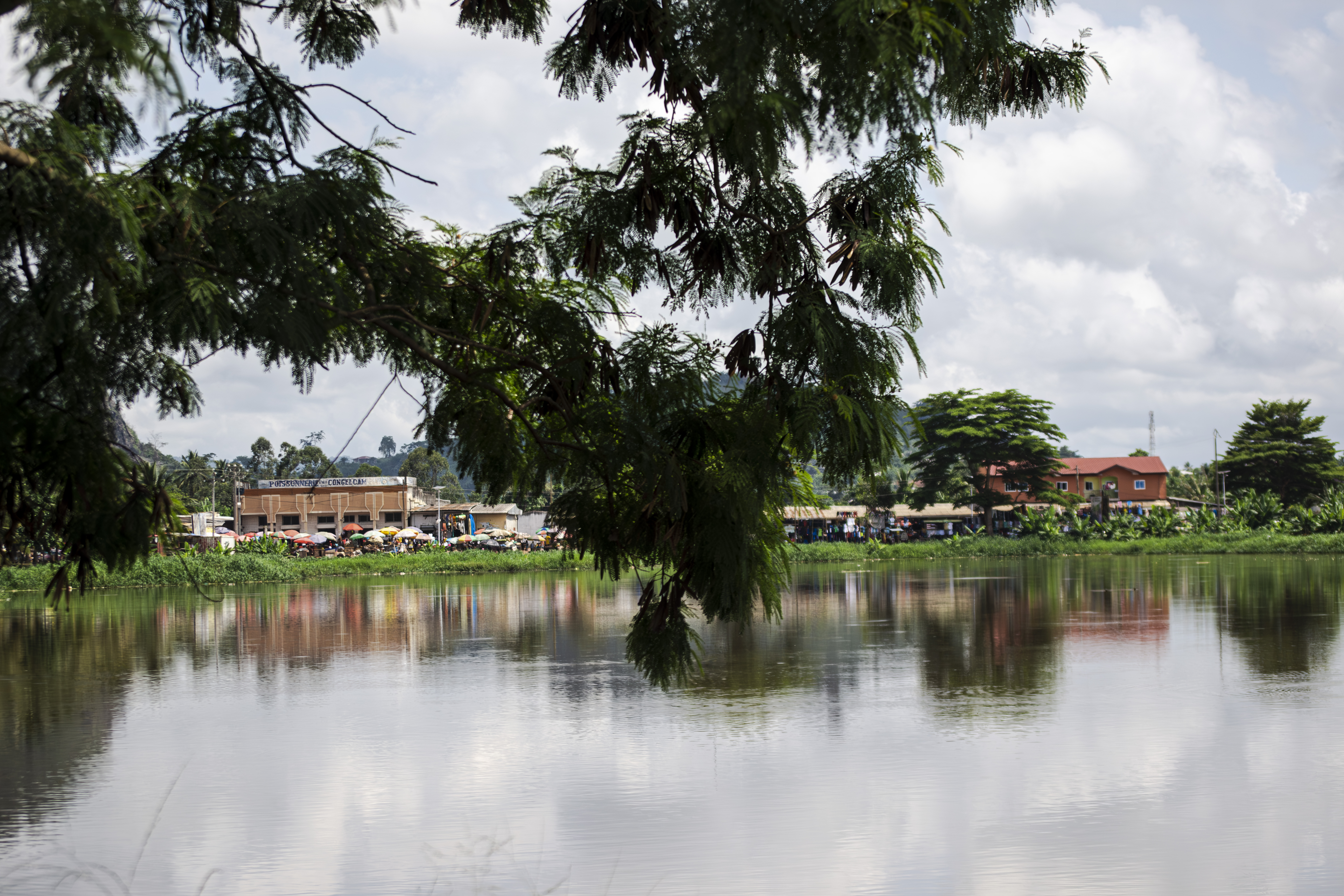 Lac municipal à Ebolowa, Cameroun, avec verdure et bâtiments publics à le background.
