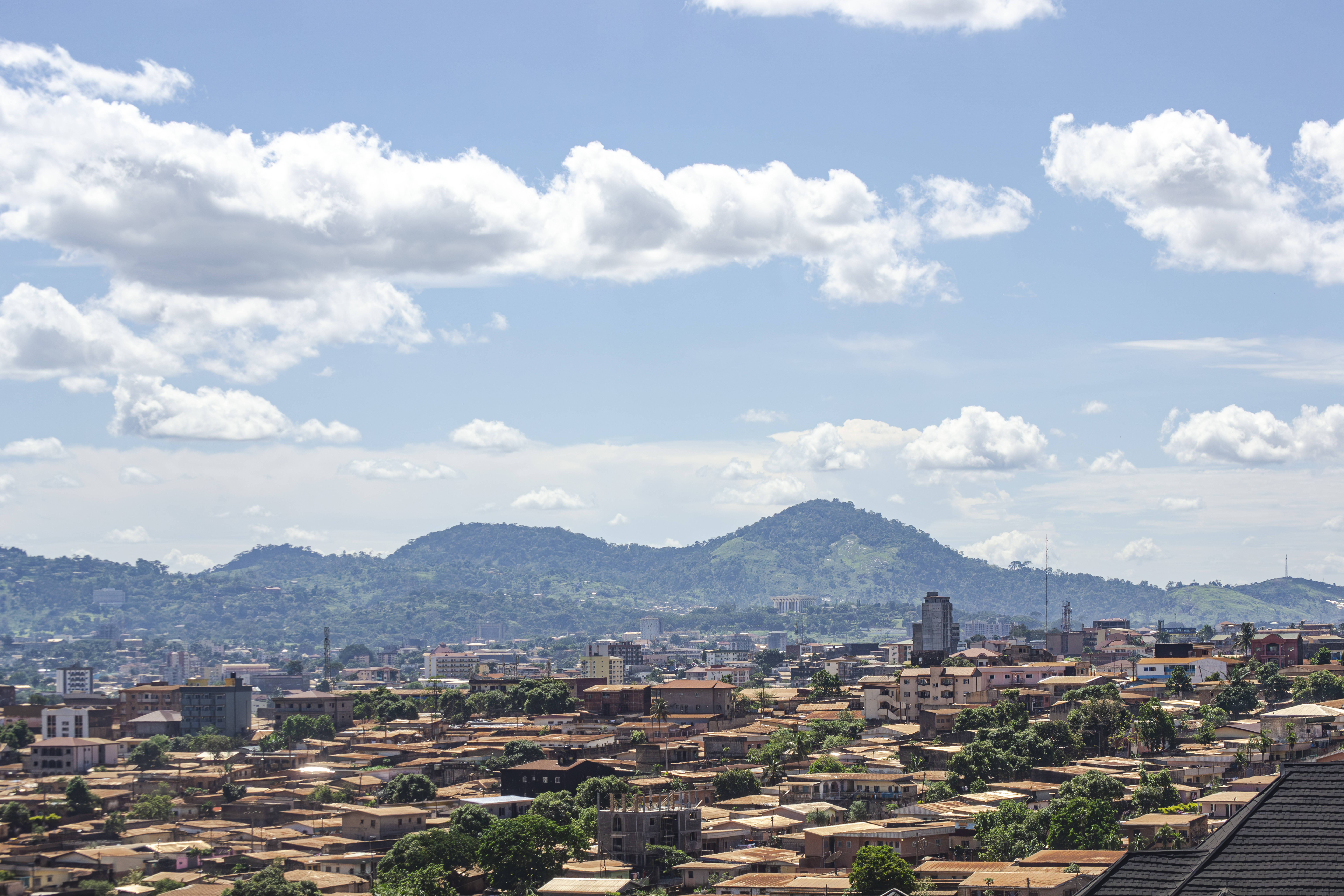 Vue aérienne panoramique de le city de yaounde à Cameroun, avec un chaîne de montagnes à le background, et un beautiful ciel bleu avec nuages.