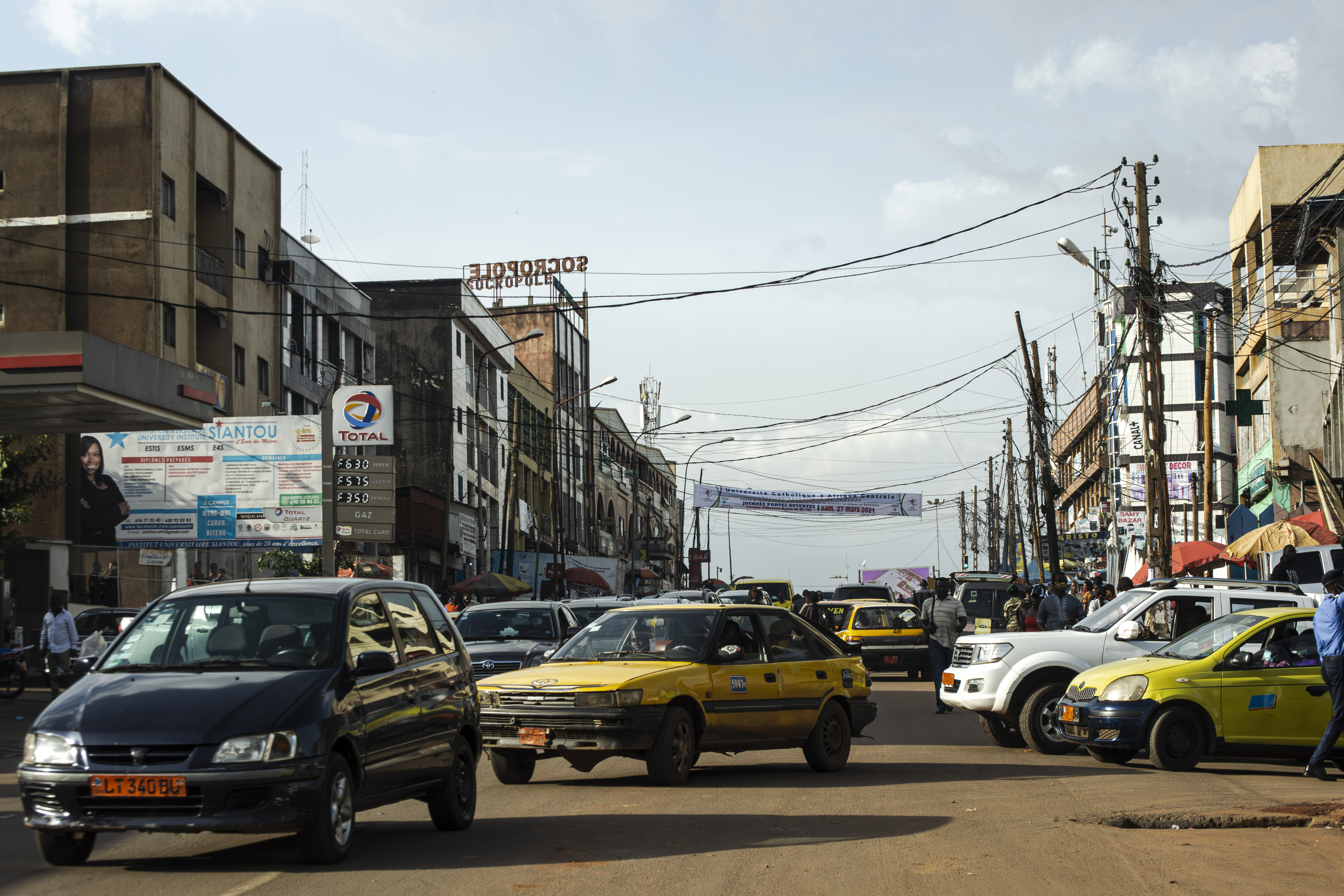 Véhicules particuliers et Taxis jaunes tournant sur un rue à le mvog-bi quartier à un lieu-dit total mvog-bi à le city de yaounde, Cameroun.