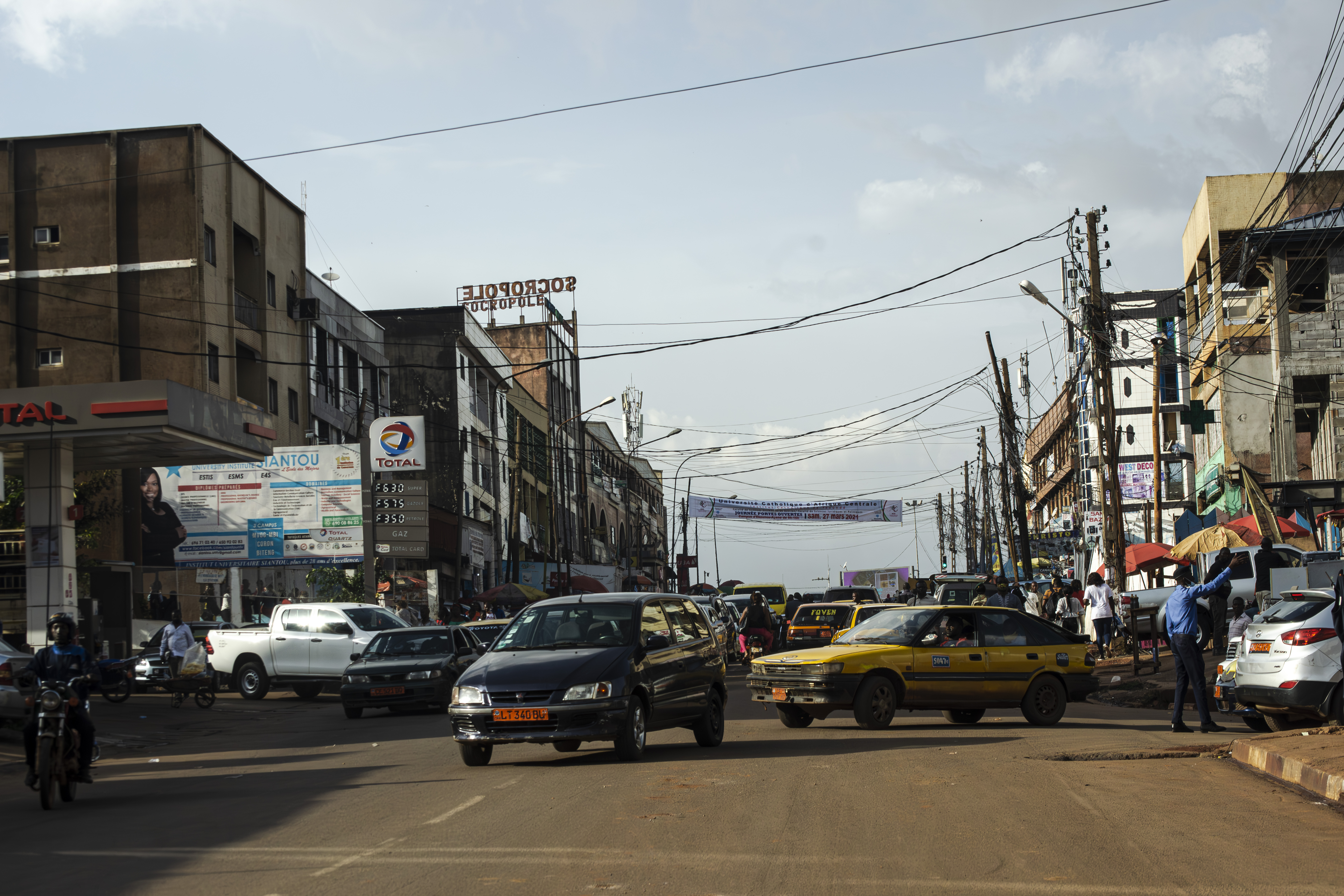 Véhicules particuliers et Taxis jaunes tournant sur un rue à le mvog-bi quartier de yaounde, Cameroun.