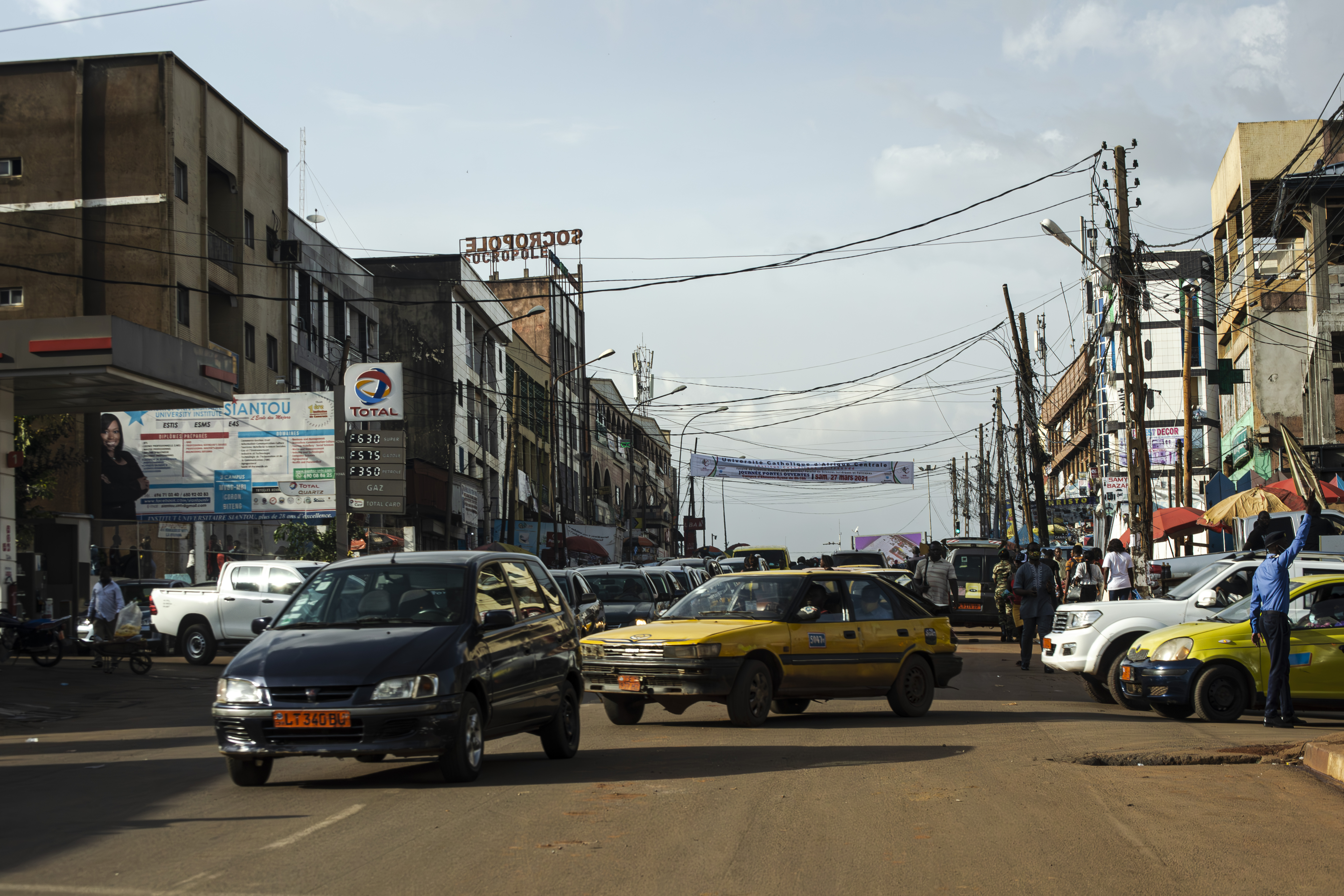 Véhicules particuliers et Taxis jaunes tournant sur un rue à le mvog-bi quartier, Cameroun.