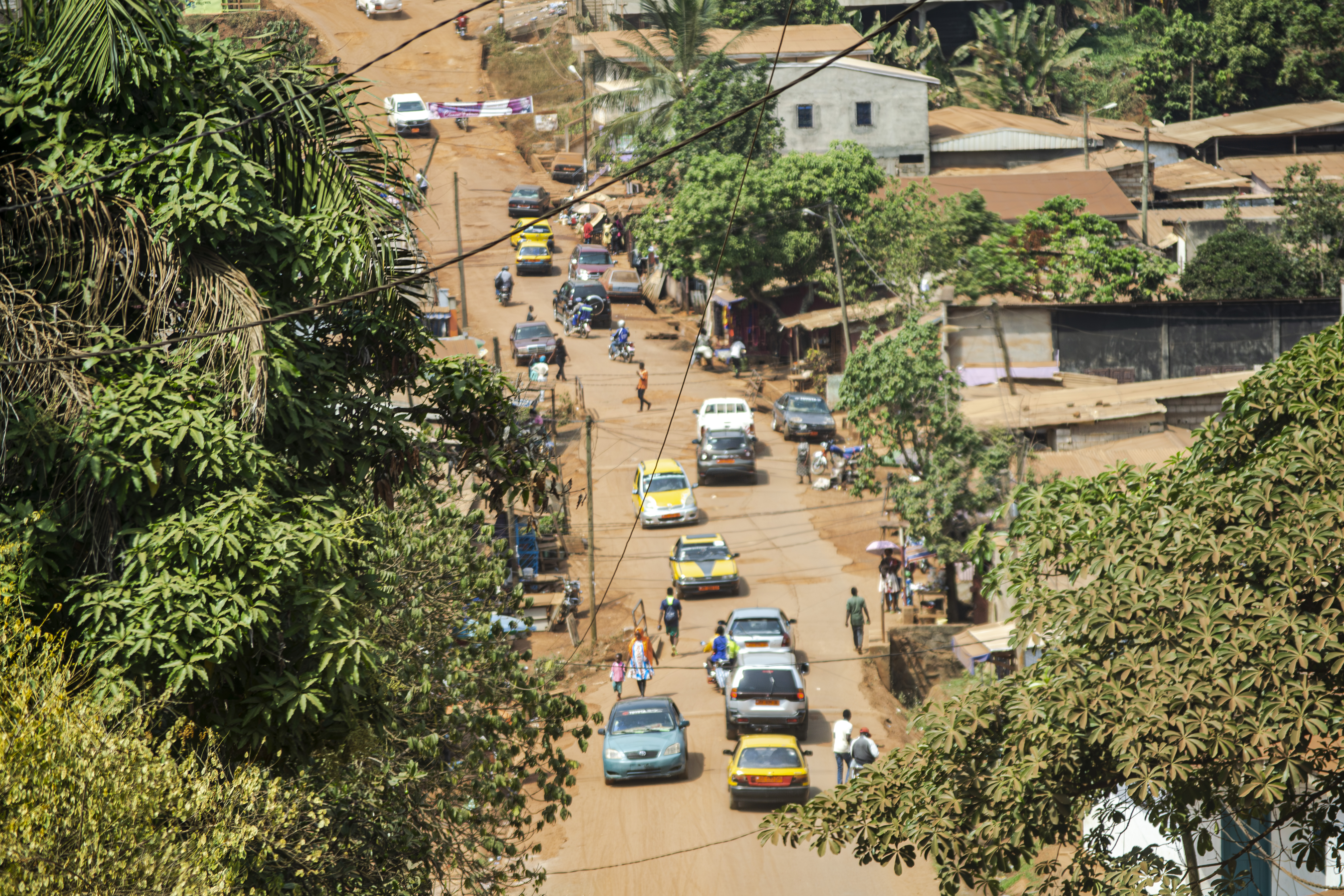 Trafic routier sur un sloping route non bitumée à le Omnisports quartier à Yaounde, Cameroun.